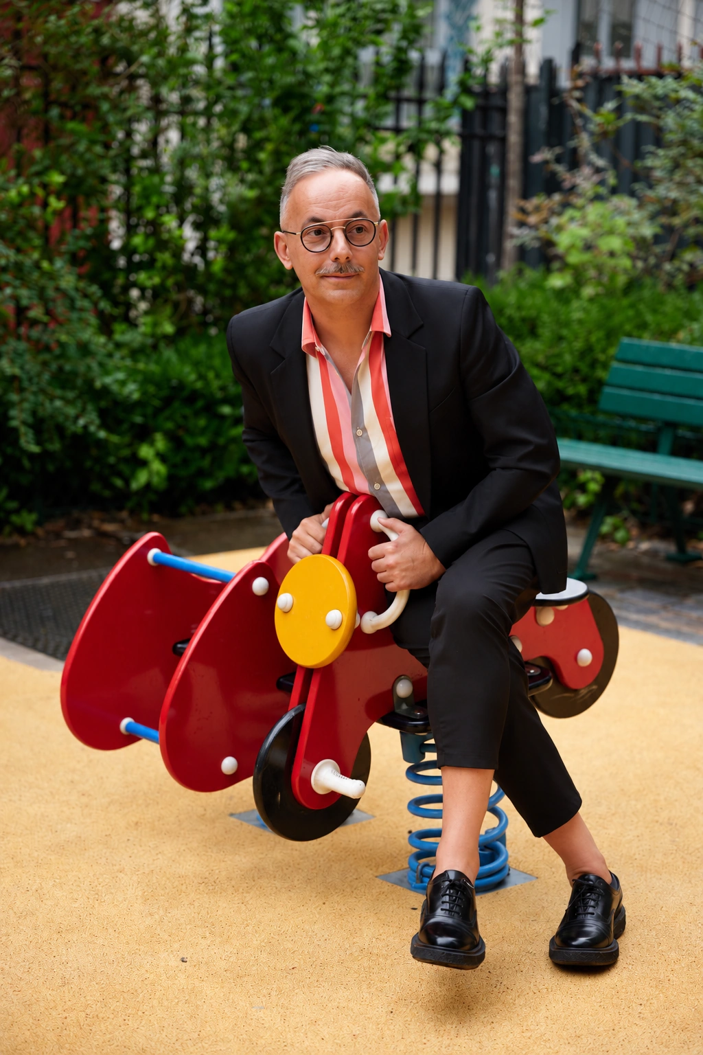 Jean-Philippe Pisanias en costume sur un jeu d'enfant à ressort